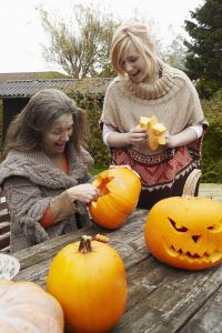 Mother and daughter carving pumpkins